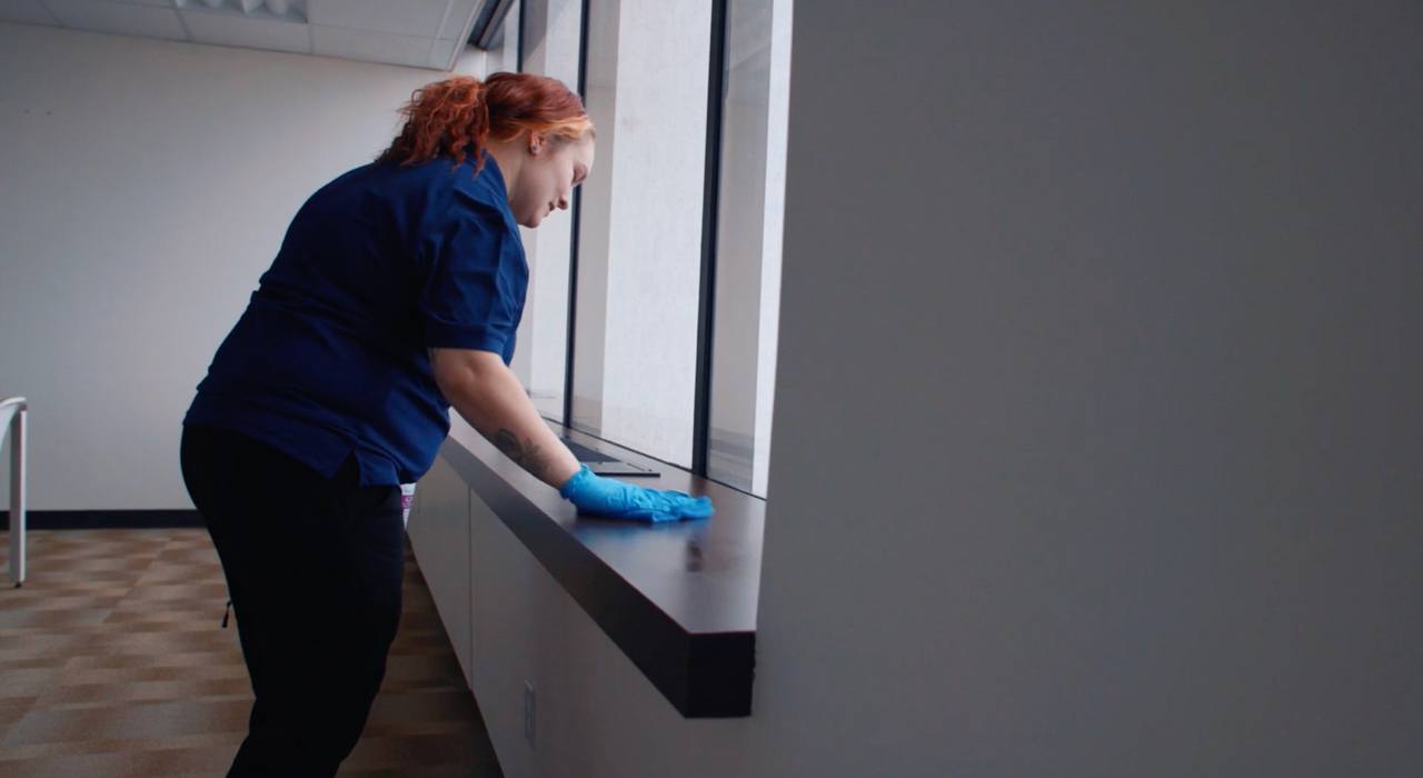 Ciocca employee cleaning window in office and area around window Ciocca employee cleaning window in office and area around window